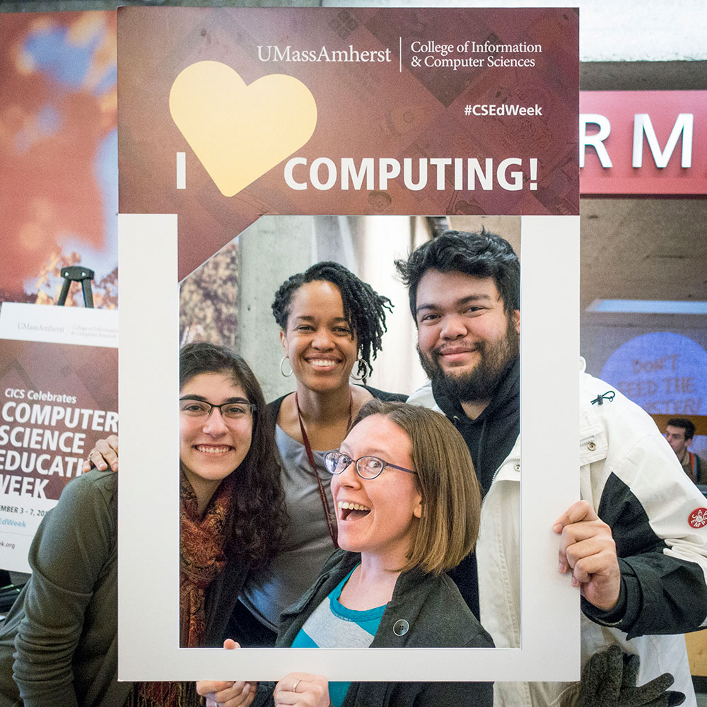 A group holding "I love computing" poster frame