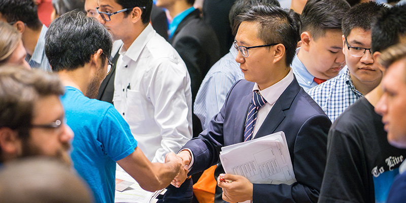 Student shaking hand with an employer at a career fair