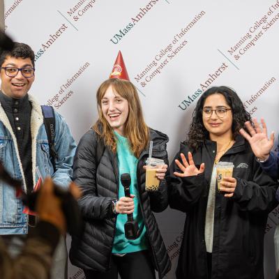 Students recording birthday greetings in front of step- and repeat banner.