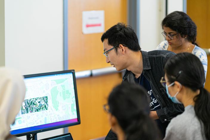 A student demonstrating his data science project on a screen