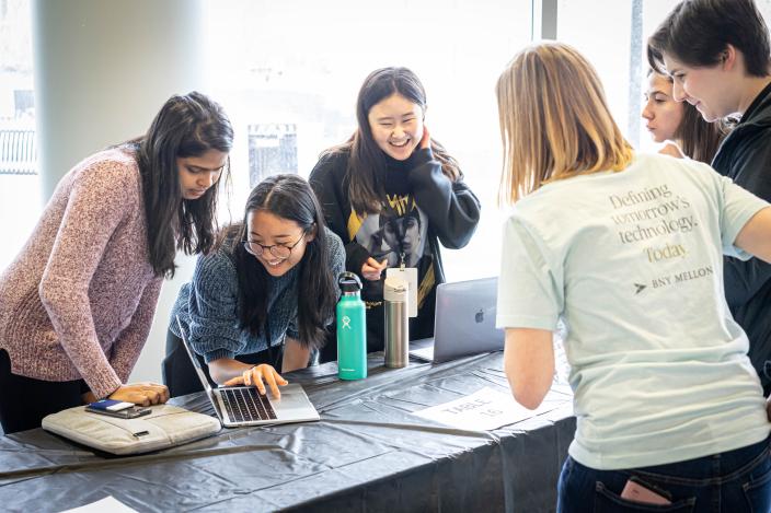 A female student demonstrating her work on a laptop