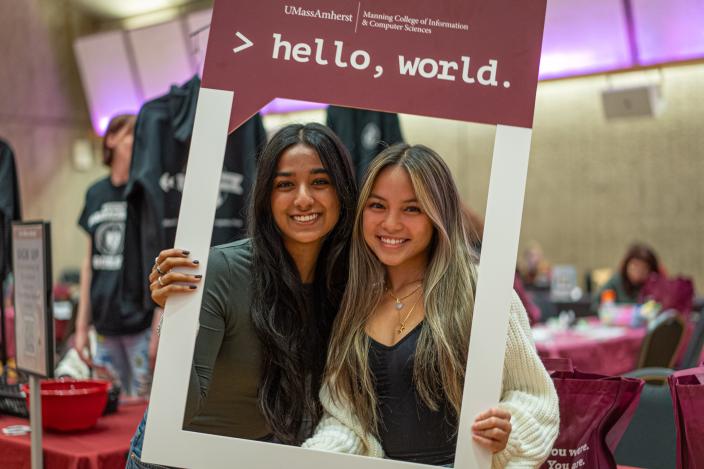 women holding photo frame that reads "Hello world"