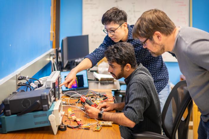 Professor working with a graduate student on a electronics projects