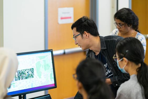 A student demonstrating his data science project on a screen