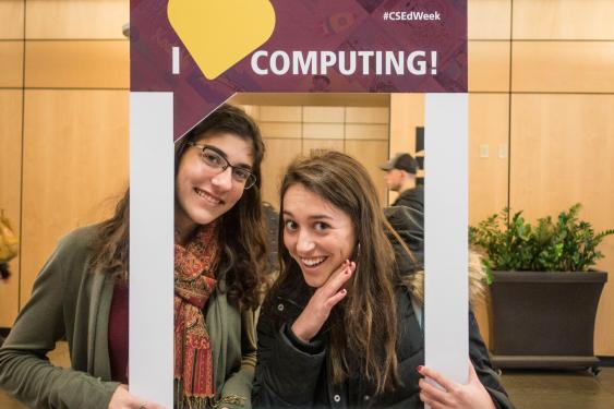 Two students posing with the I [heart] computing photo frame