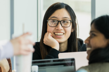 Female student smiling while having a lively discussion