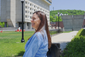 Ivon arroyo smiling as she walks across the campus of UMass Amherst