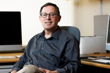 Manning College of Information and Computer Sciences Professor Shlomo Zilberstein sits in front of computers in his office