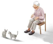 Seated elderly woman watches her cats