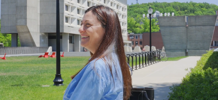 Ivon arroyo smiling as she walks across the campus of UMass Amherst