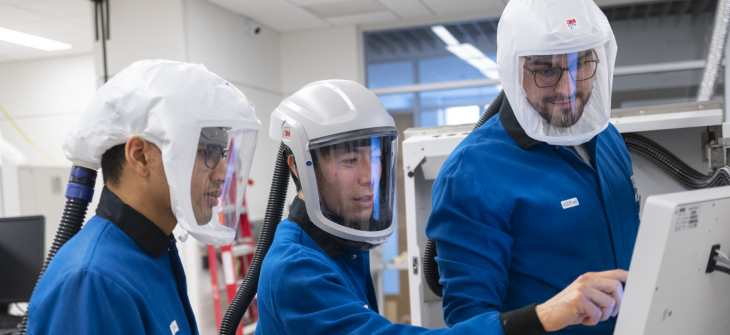 researchers in a lab wearing protective gear