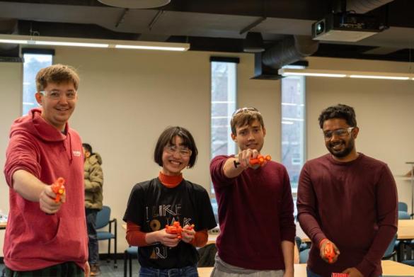 Cooper Sigrist (left) and other CICS graduate students take place in Capture-the-Flag around the Lederle Graduate Research Center