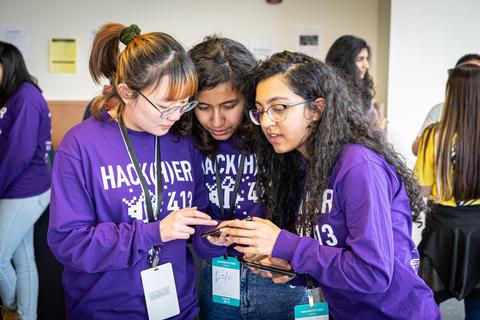 Students gathering around cellphone during hackathon