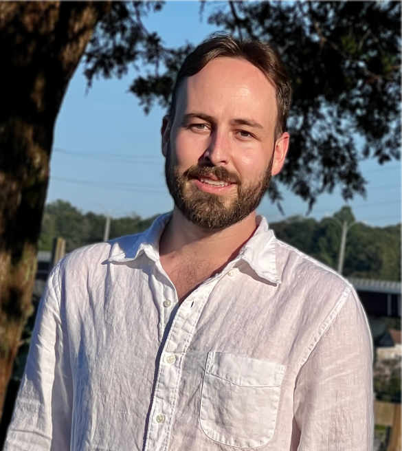 A photo of Dylan Foster outside standing near trees