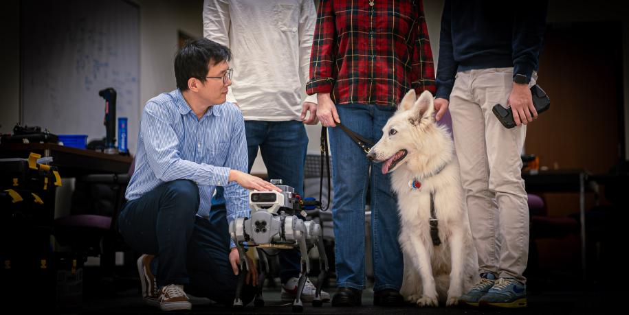 Donghyun Kim kneels next to robot guide dog and Brawny